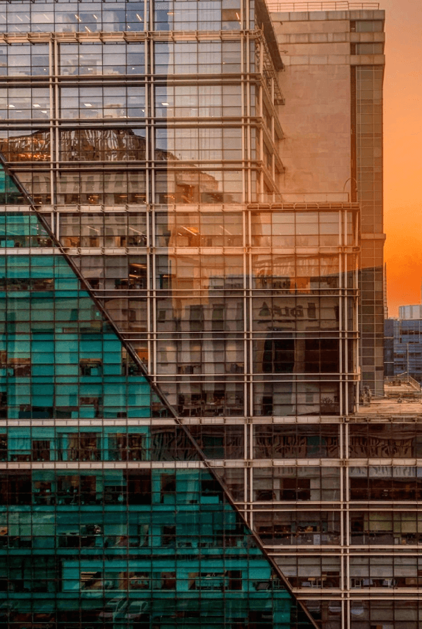 Modern building facade with abstract reflections and warm lighting.